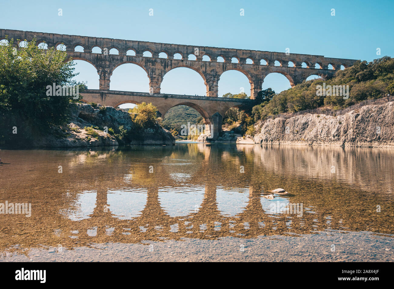 Schöne Sicht auf die alte römische Brücke Pont du Gard in der Mitte der Fluss Gardon Stockfoto