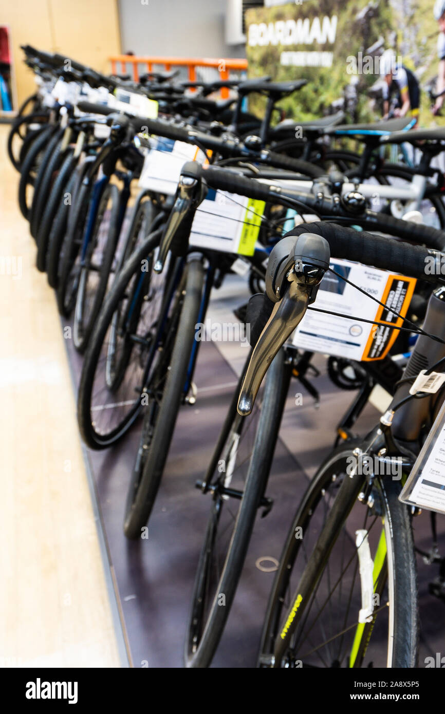 Zeilen Mountainbikes und Rennräder im Verkauf bei der halfords Store, Shop auf der High Street in der Nähe der Innenstadt Stockfoto