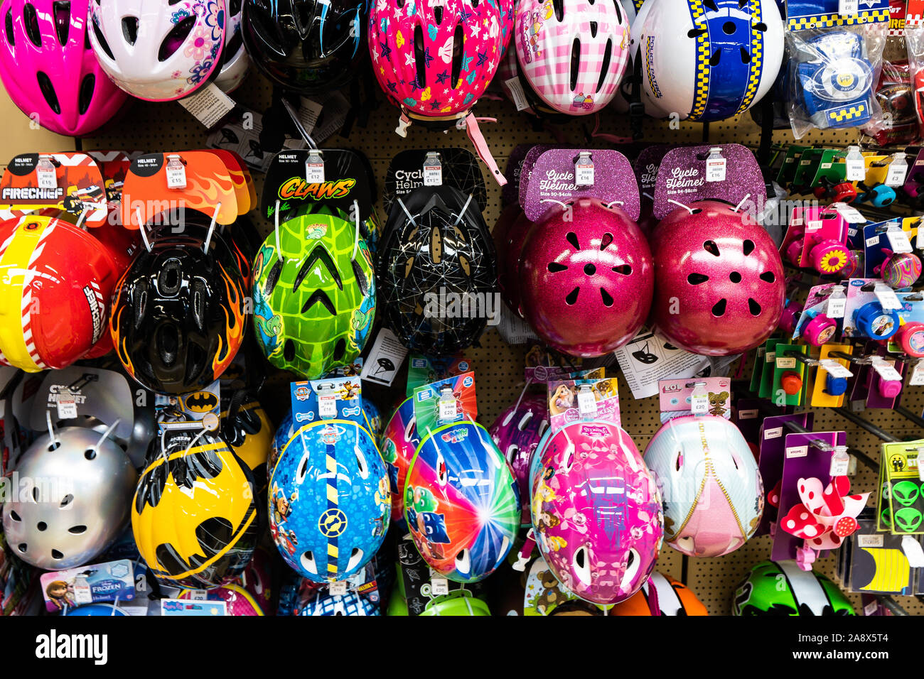 Kinder und Erwachsene Radfahren, Skaten und Skaten Schutzhelme zum Verkauf an der lokalen Halfords Store auf der Hohe Straße in der Stadt Stockfoto