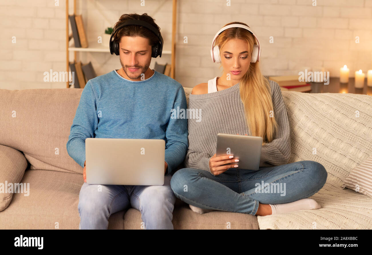 Paar mit Notebook und Tablet-PC Sitzen auf einem Sofa Indoor Stockfoto