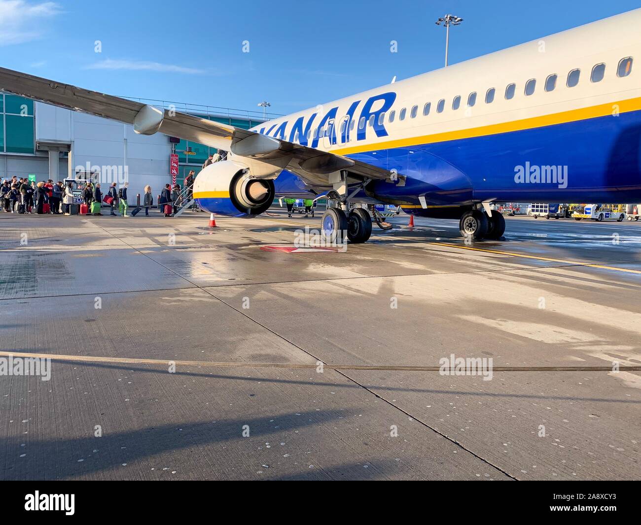 London, England - November 9th, 2019: Warteschlange von Menschen warten auf ein Flugzeug Ryanair am Flughafen Stansted in einem kalten sonnigen Tag zu erhalten Stockfoto