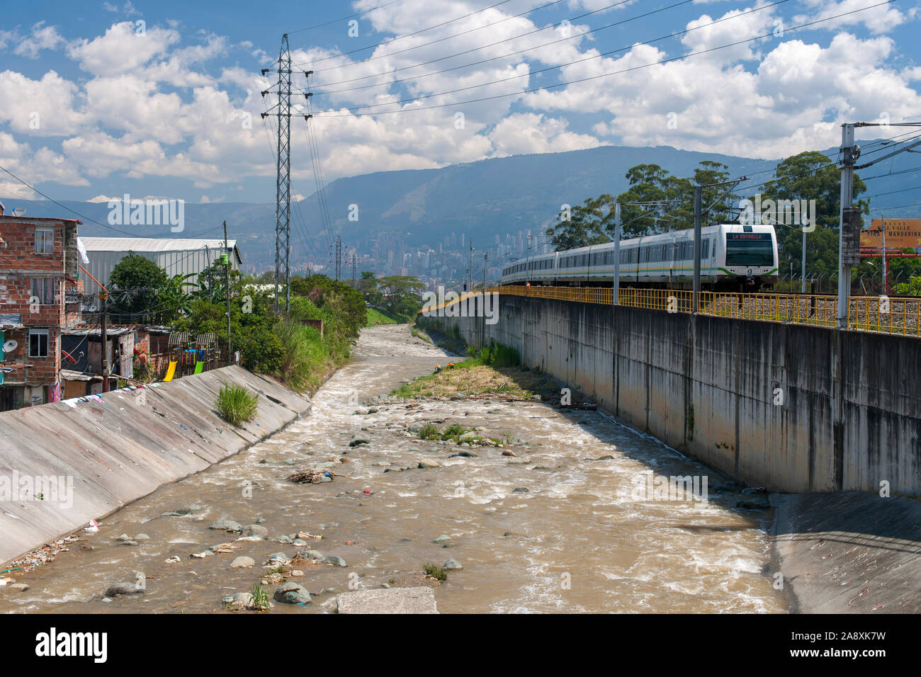 Die U-Bahn im La Estrella station am Stadtrand von Medellin, Kolumbien anreisen. Der Fluss ist die Medellin River. Stockfoto