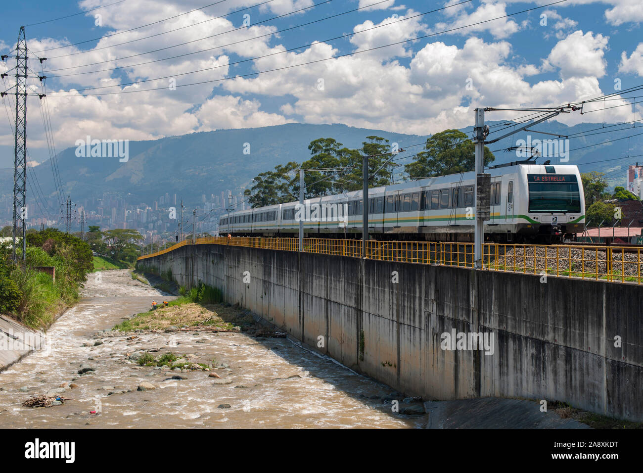 Die U-Bahn im La Estrella station am Stadtrand von Medellin, Kolumbien anreisen. Der Fluss ist die Medellin River. Stockfoto