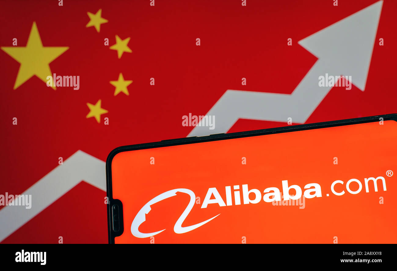 Alibaba Logo auf dem Smartphone und verschwommenes Bild mit Flagge von China mit Pfeil im Hintergrund. Konzeptionelle Foto. Stockfoto