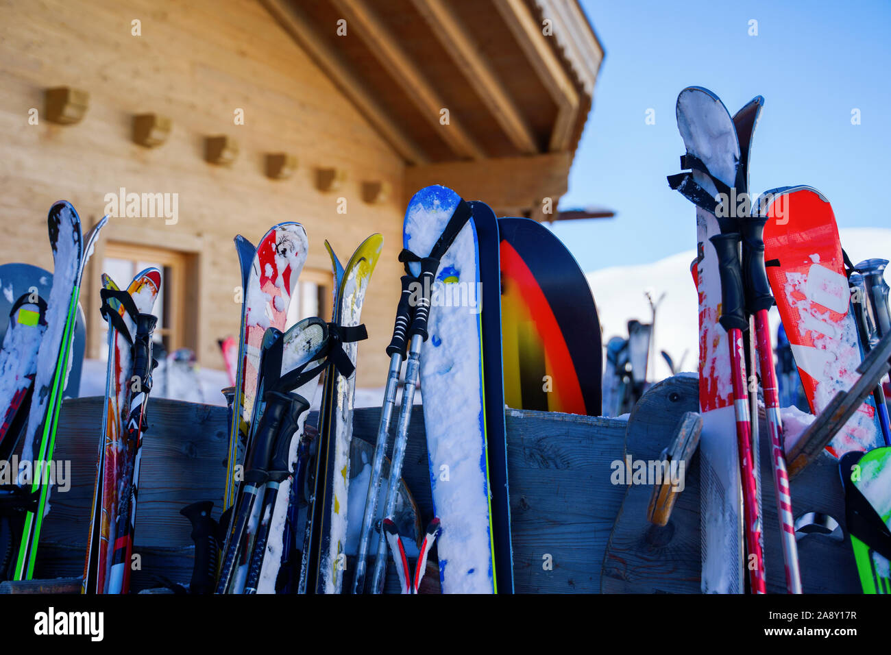 Bild von mehrfarbigen Skier und Snowboards auf Schnee im Winter Resort am Nachmittag. Unscharfer Hintergrund. Stockfoto