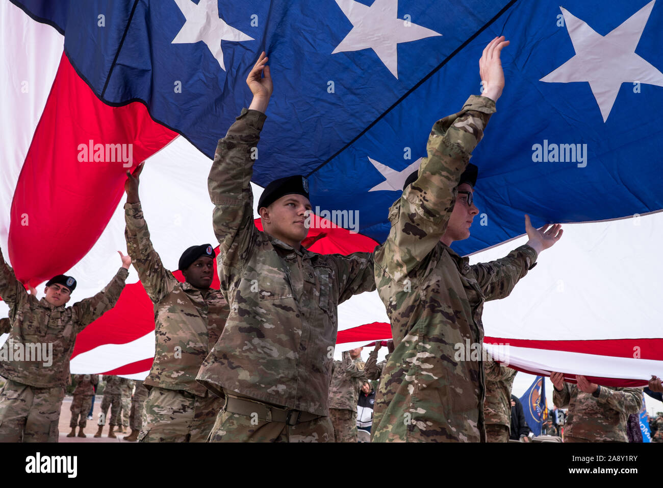 El Paso, Texas, USA. 11 Nov, 2019. Soldaten des 1.Bataillon, 77. Armor Regiment, 3. gepanzerte Brigade Combat Team 'Bulldogge'', 1st Armored Division, eine amerikanische Flagge während der Feier ist ein Veteran in El Paso, Texas. Quelle: Joel Engel Juarez/ZUMA Draht/Alamy leben Nachrichten Stockfoto