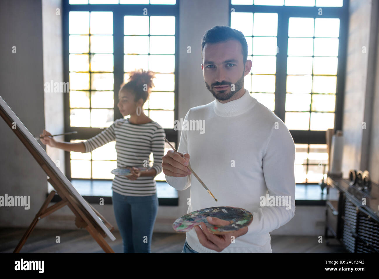 Schöne bärtige Künstler tragen weiße Rollkragen Stockfoto