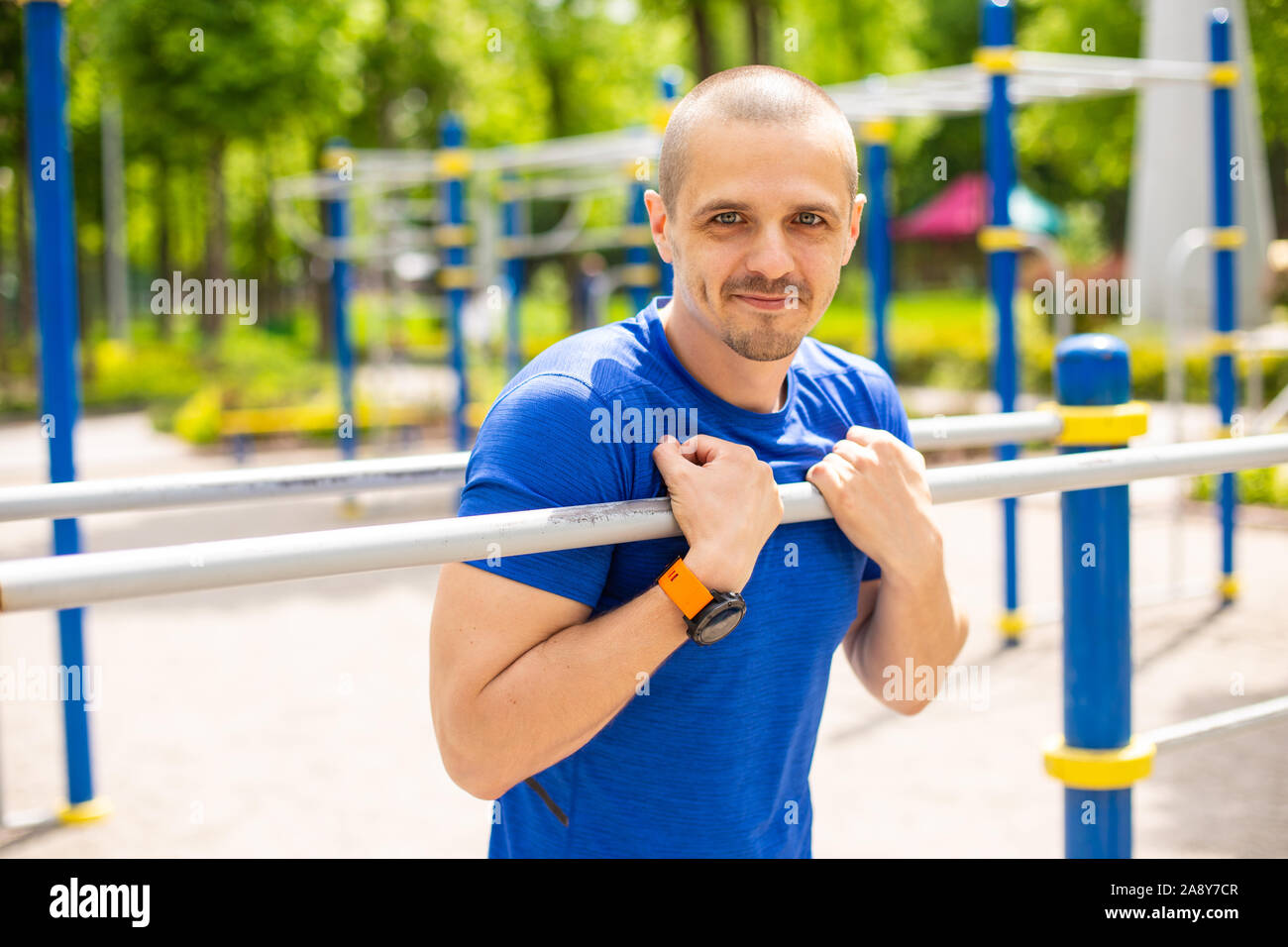 Athletischer Mann lehnte sich auf Bars und Suchen in der Kamera Stockfoto