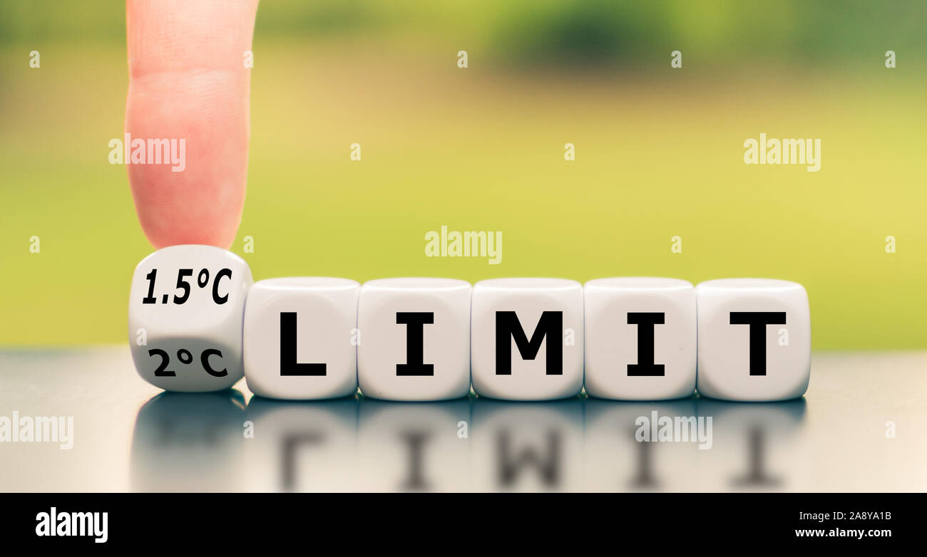 Symbol für eine Begrenzung der globalen Erwärmung. Hand einen Würfel und Änderungen der Ausdruck "2°C-Grenze' zu '1,5 °C limit', oder umgekehrt. Stockfoto