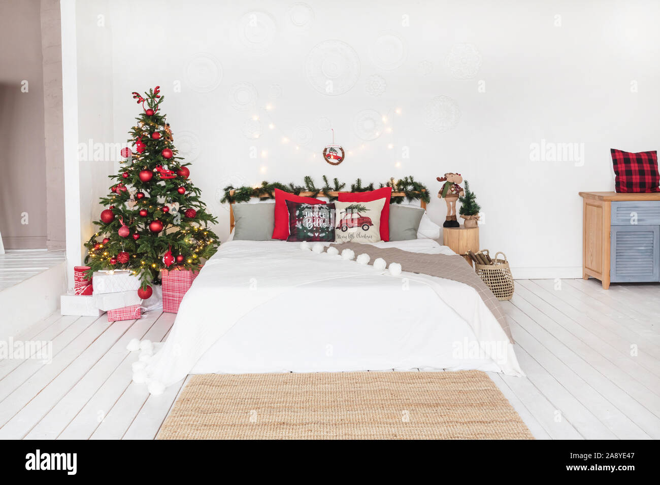 Weiß Schlafzimmer im Loftstil mit roten Weihnachten Dekor. Stockfoto