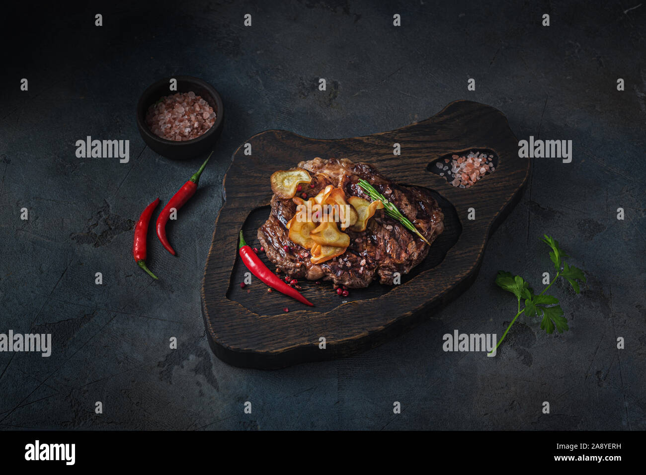 Rindersteak mit knusprigen Pastinaken Chips, dunkle Foto. Stockfoto
