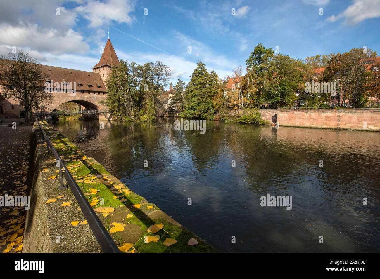 Einen schönen Blick auf den Fluss in der Nähe der Altstadt von Nürnberg in Deutschland. Die Kettenbrücke können in der Ferne zu sehen ist, mit dem ehemaligen Schiess Haus, Stockfoto