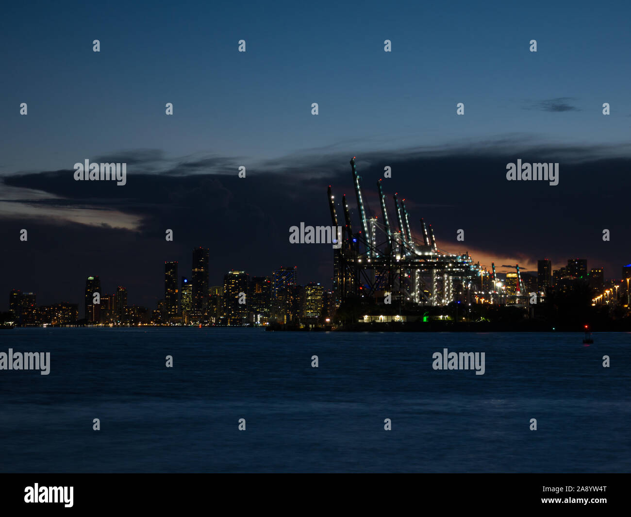 Sonnenuntergang Panorama der Hafen von Miami, Fisher Island und Downtown, bunte Stadt Licht und Biscayne Bay Wasser Stockfoto