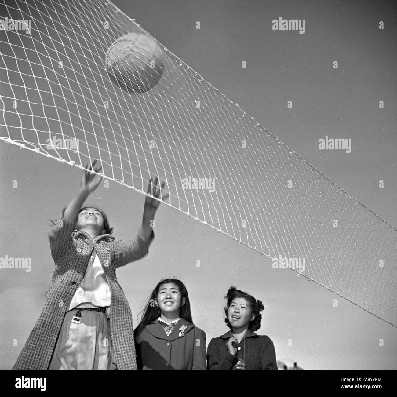 Manzanar Relocation Center, Manzanar, Kalifornien. Mädchen aus der sechsten Klasse verbringen Aussparung in einem leidenschaftlich Volleyball 2/10/1943 Stockfoto