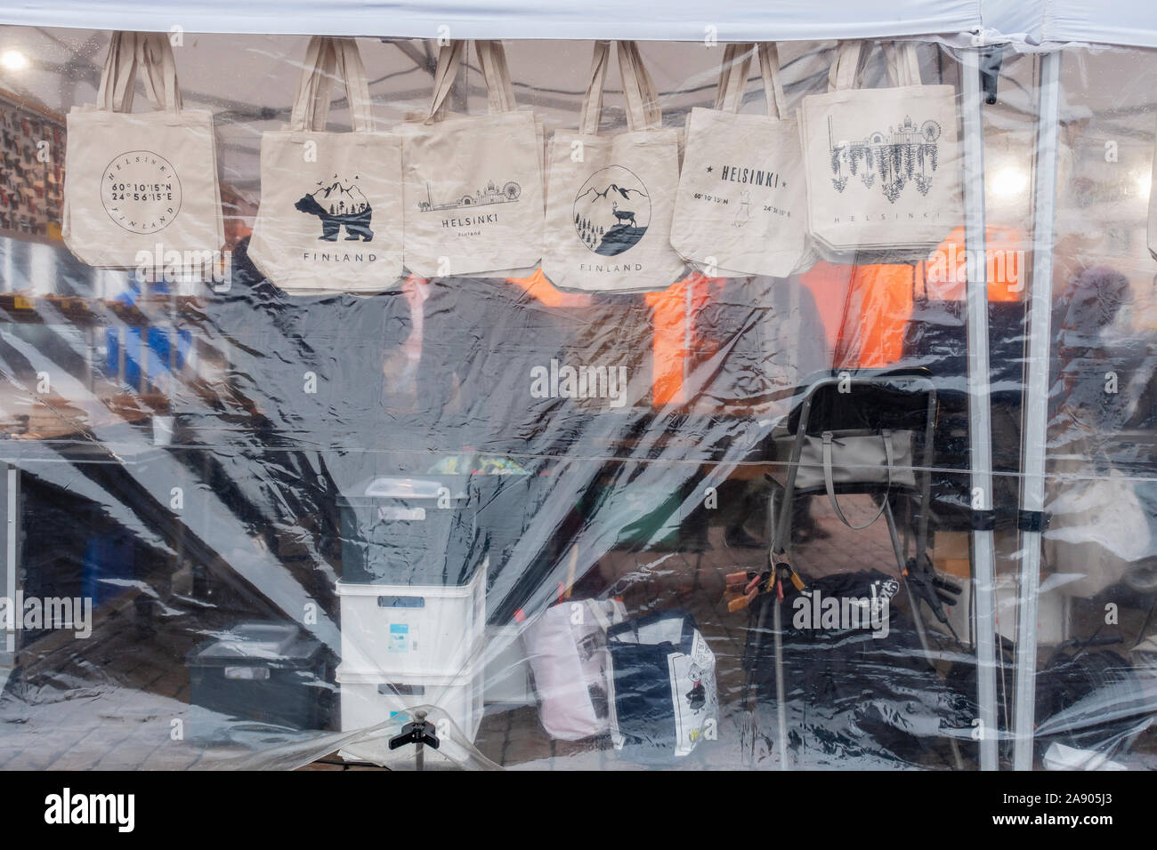 Tragetaschen hinter der transparenten Kunststoffwand am Marktplatz in Helsinki Finnland Stockfoto