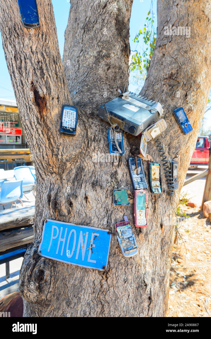 Sammlung von alten kaputten Handys an einen Baum außerhalb des beliebten Outback Pub Sheepyard Inn, die grawin, Lightning Ridge, New South Stockfoto