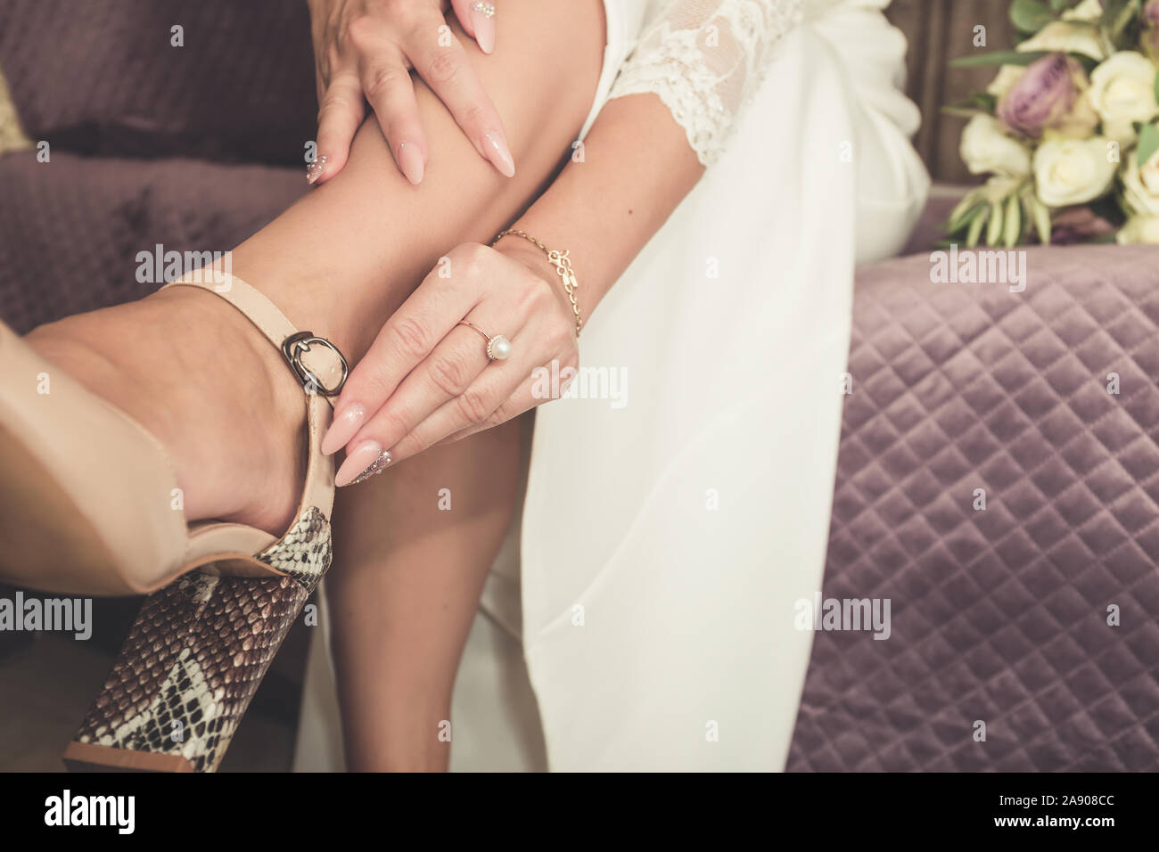 Braut setzt auf Hochzeit Schuhe auf Ihre zarten Füße Stockfoto