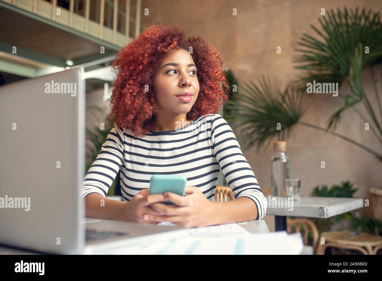 Junge Frau mit Telefon, während Sms ihr Freund Stockfoto