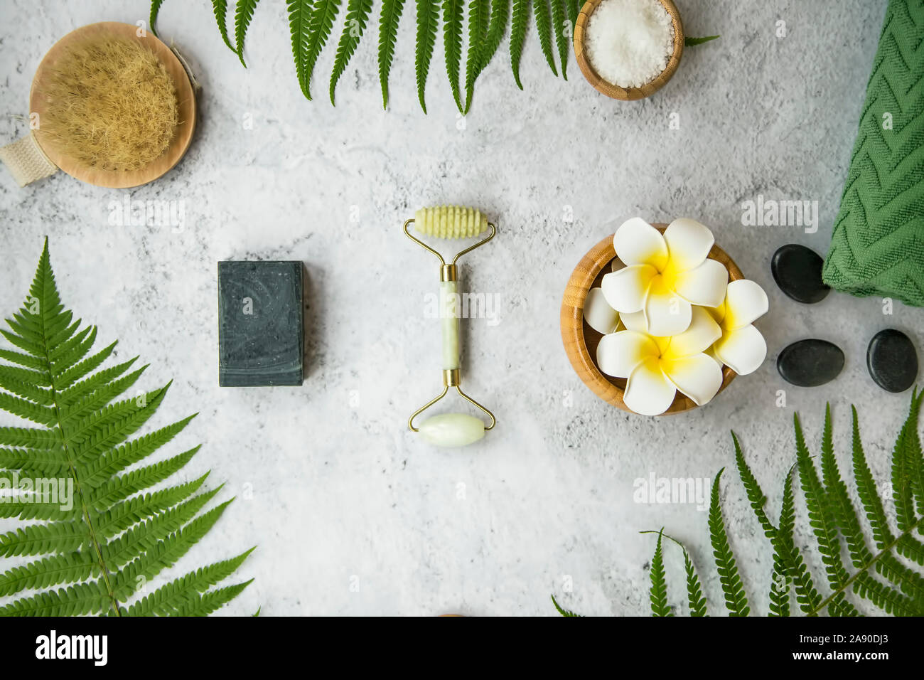 Spa Noch leben Einstellung mit Frangipani Blüten, natürliche Seife, Walze, Badesalz, Massage Steine, Handtuch und grüne Blätter, Wellness und Spa en Stockfoto