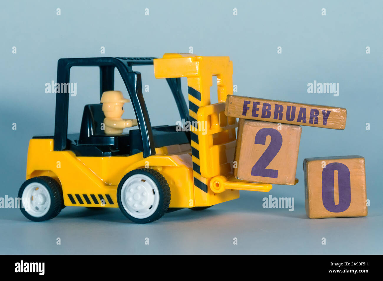 Februar 20th. 20. Tag des Monats, der Bau oder die Lager Kalender. Gelb Spielzeug Gabelstapler Last Holz Würfel mit Datum. Arbeit Planung und Zeitmanagement. Stockfoto