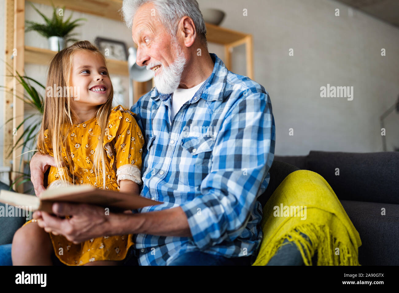 Großvater lesen Buch mit seiner Enkelin zu Hause. Happy Family Zeit Stockfoto