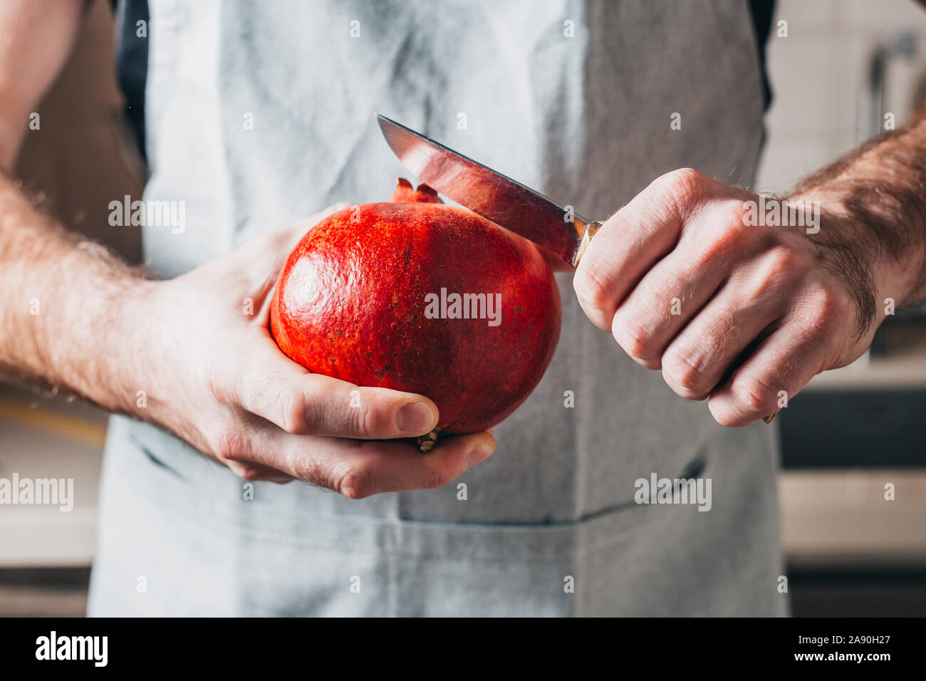 Koch reinigt Granatapfel in festlicher Salat - Rezepte Stockfoto