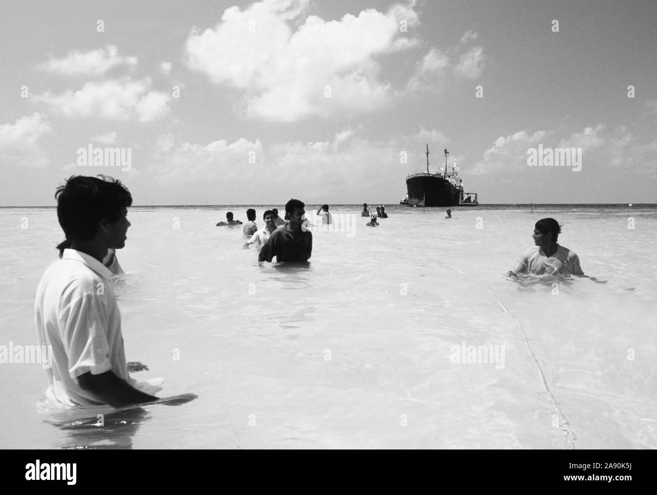 Malediven Insel: Völker versuchen, eine alte Fracht - Schiff vor der Coral Reef es für eine neue Unterwasser zu sinken - Bevölkerung von Riff zu ziehen Stockfoto