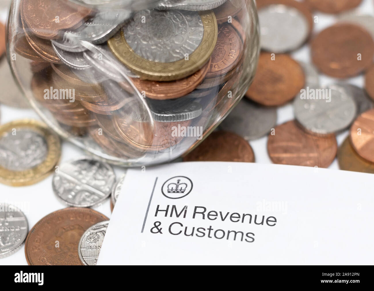 London/Großbritannien - 11. November 2019 - HMRC logo Briefpapier und Geld jar mit Münzen. Ihrer Majestät Einnahmen und Zoll ist eine nicht-ministerielle Abteilung Stockfoto