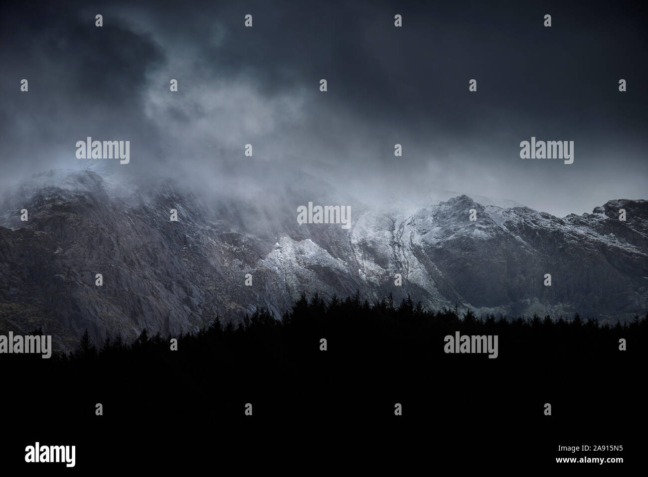 Atemberaubende dramatische Landschaft Bild von schneebedeckten Glyders Bergkette in Snowdonia im Winter mit bedrohlichen Wolken am Berg Erbse hängen Stockfoto