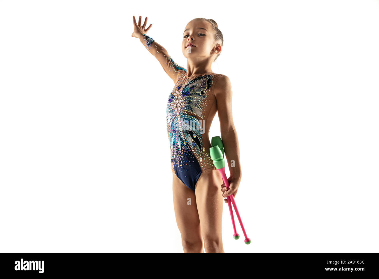 Wenig flexible Mädchen auf weißem studio Hintergrund isoliert. Wenig weibliche Modell als rhythmische Gymnastik artist in hellen Turnanzug. Gnade in Bewegung, Action und Sport. Übungen mit dem streitkolben. Stockfoto