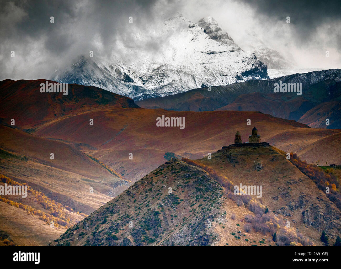 Hohen Kaukasus, Anzeigen Gergeti Kloster der Heiligen Dreifaltigkeit, mit dem Kazbeg Auswahl als Hintergrund. Foto von Stephantsminda genommen. Stockfoto