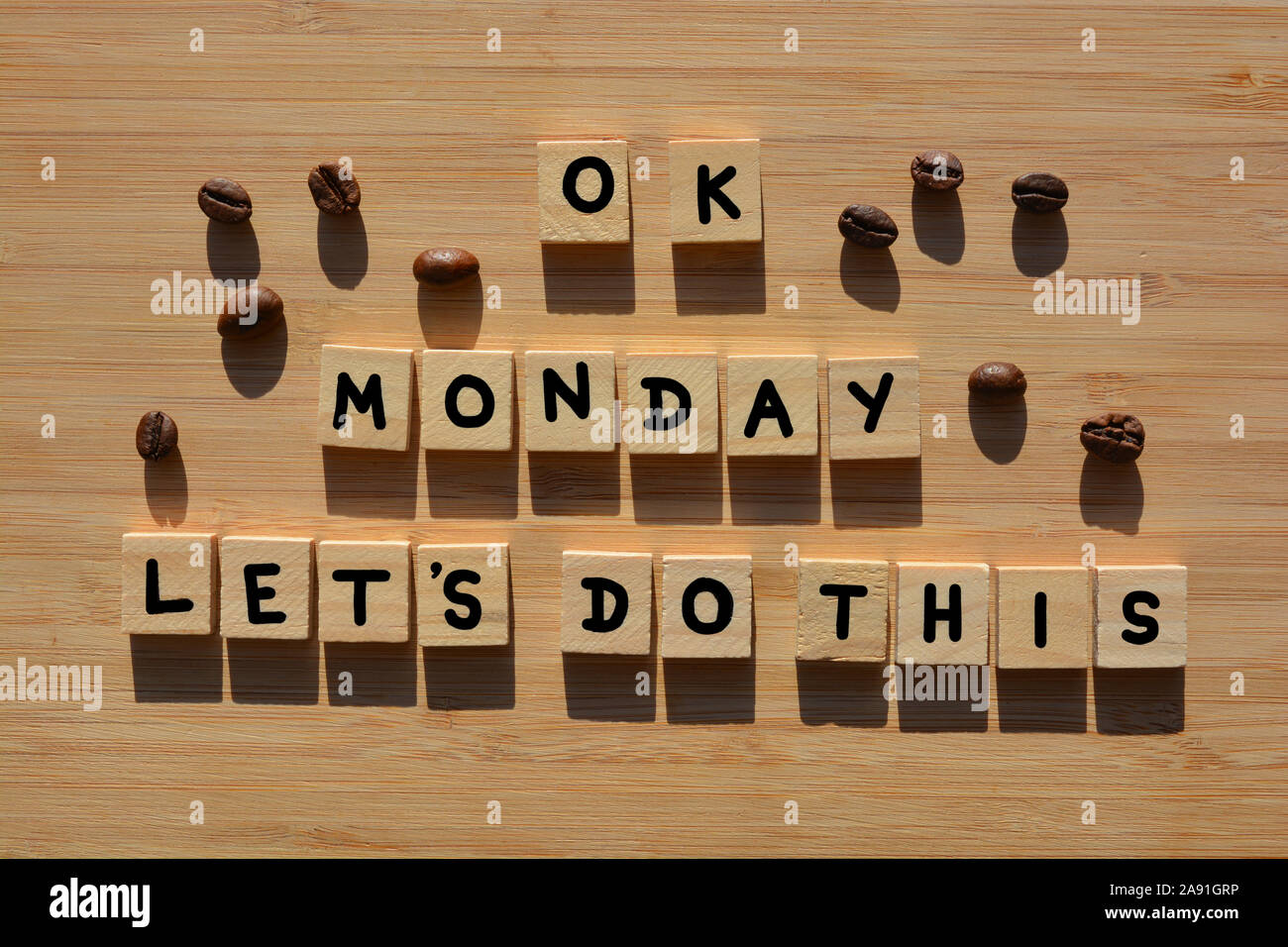 OK Montag, lassen Sie uns dies tun in 3D Holz- Buchstaben des Alphabets mit Kaffeebohnen auf einem Bambus Holz Hintergrund Stockfoto