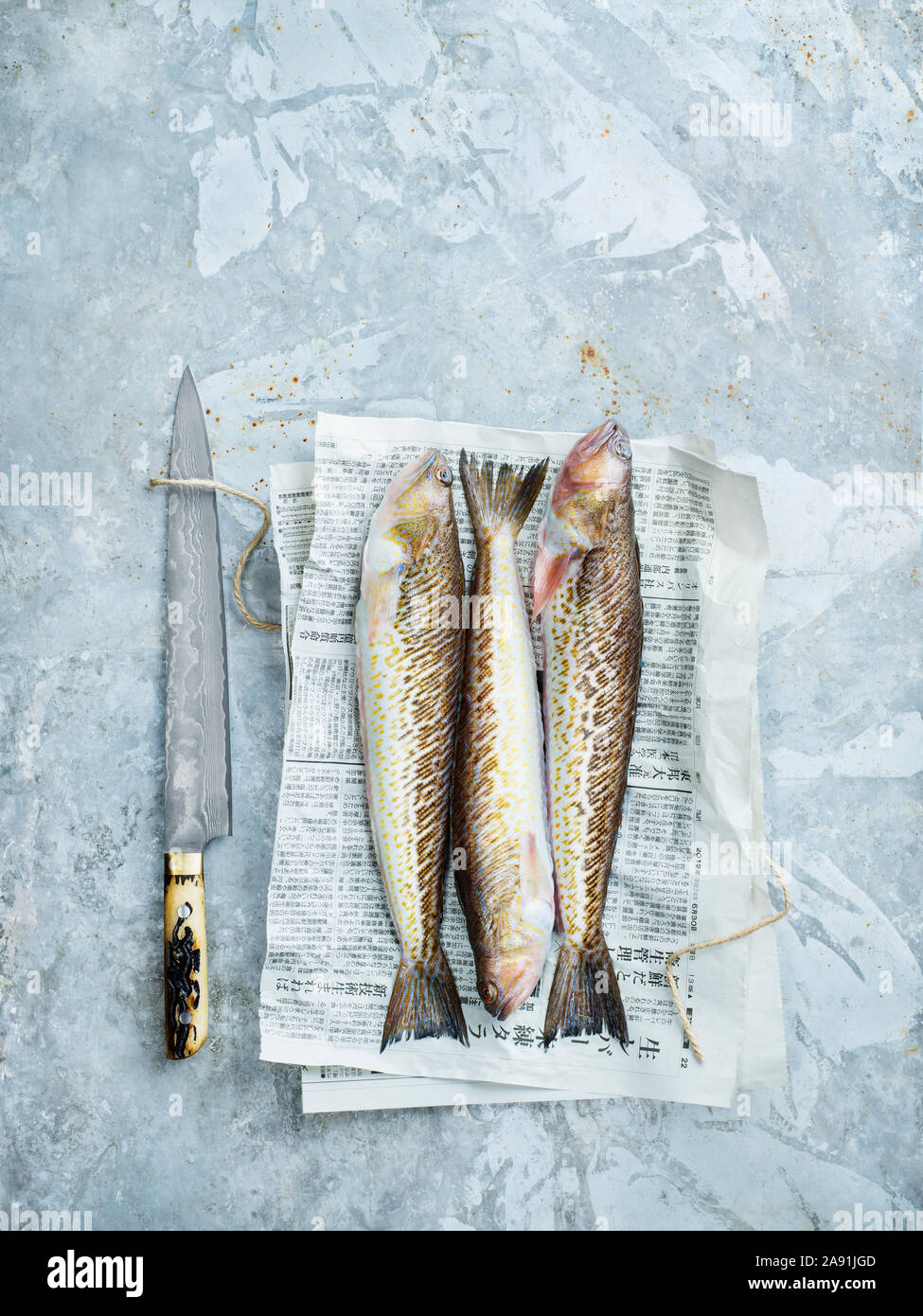 Messer und rohen Fisch auf Zeitung Stockfoto