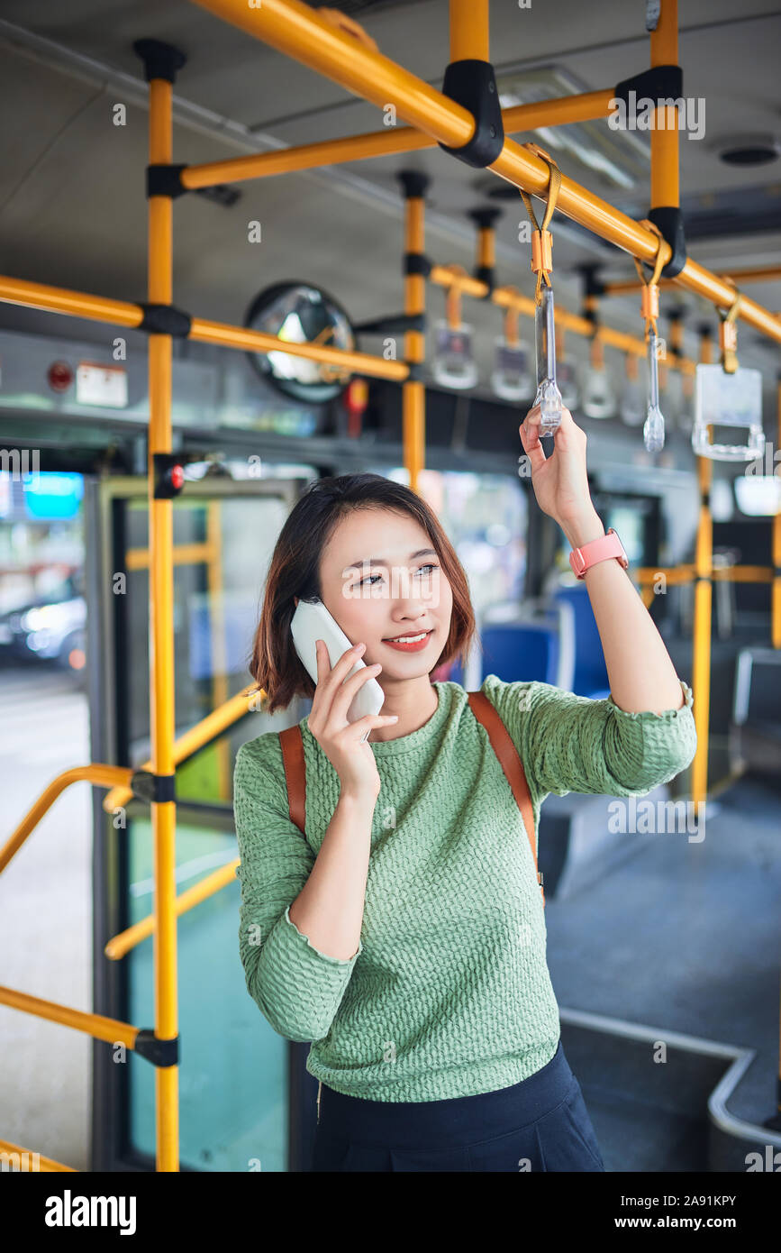 Schöne weibliche Pendler Gespräch am Handy während der Bus zu arbeiten Stockfoto
