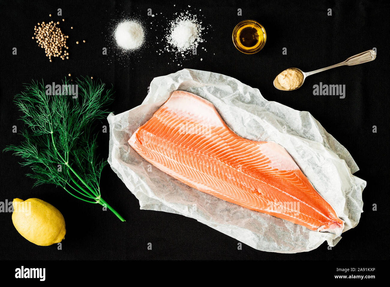 Zutaten für gebackenen Lachs auf schwarzem Hintergrund Stockfoto