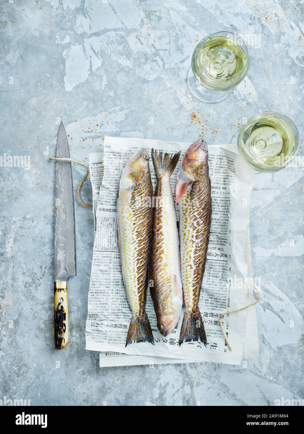 Messer und rohen Fisch auf Zeitung Stockfoto