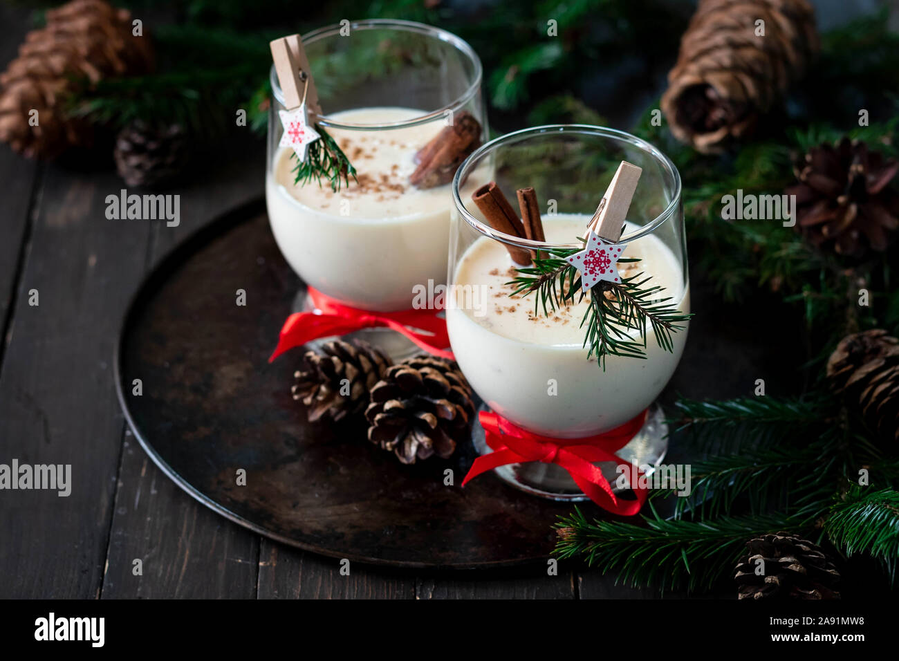 Ein traditionelles Eierlikör Weihnachten Drink in ein Glas Becher dekoriert mit neuen Jahr Wäscheklammer. Nicht-alkoholische Option. Stimmungsvolle Fotos. Stockfoto