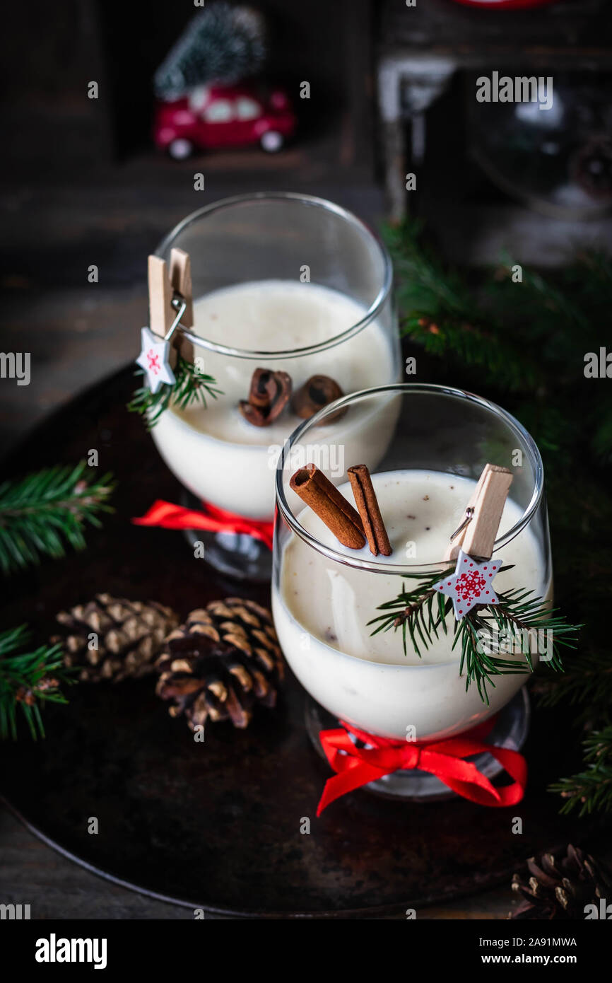 Ein traditionelles Eierlikör Weihnachten Drink in ein Glas Becher dekoriert mit neuen Jahr Wäscheklammer. Nicht-alkoholische Option. Stimmungsvolle Fotos. Stockfoto