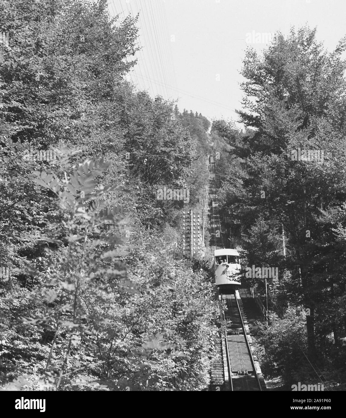 1950s, historisch, eine schweizer Bergbahn oder ein Wagen mit den Buchstaben SMS auf der Vorderseite, die von der Spitze des Mont-Soleil, einem Gipfel des Juras, in die Stadt Saint Imier, Bern, Schweiz, absteigt, eine Reise, die 1903 gegründet wurde. Eine Standseilbahn ist eine Seilbahnform an einem steilen Hang, an dem zwei Waggons an entgegengesetzten Enden einer Transportleitung befestigt sind. Stockfoto