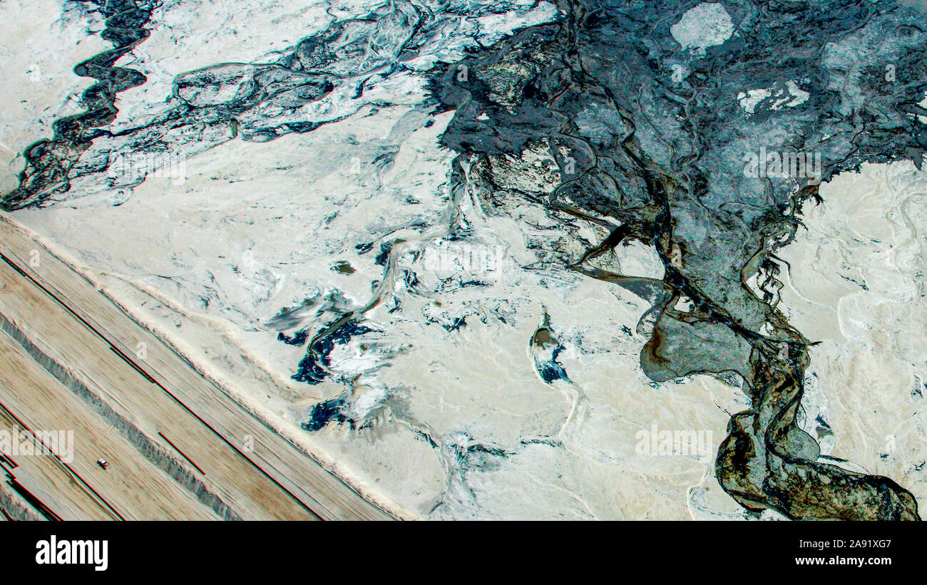 Pick-up Trucks Pass durch die enormen Bergeteiche in Fort McMurray in Alberta, Kanada. Die Teiche sind unter der größte Mann, Strukturen in der Welt, die mehr als 175 Quadratkilometern. Sie stellen eine zusätzliche Herausforderung an die Oil Sands Produktion: auch nach Ende der Produktion, kann es bis zu 30 Jahre für den Schlick, die in den Teichen bis zu trocknen. Das kontaminierte Wasser ist giftig für alle Lebewesen. Die Athabasca Oil Sands Kaution gehört zu den größten in der Welt. Die Bitumen, auch allgemein namens tar (tar sands), enthält viele Kohlenwasserstoffe, sondern ist notorisch schwer zu ext. Stockfoto