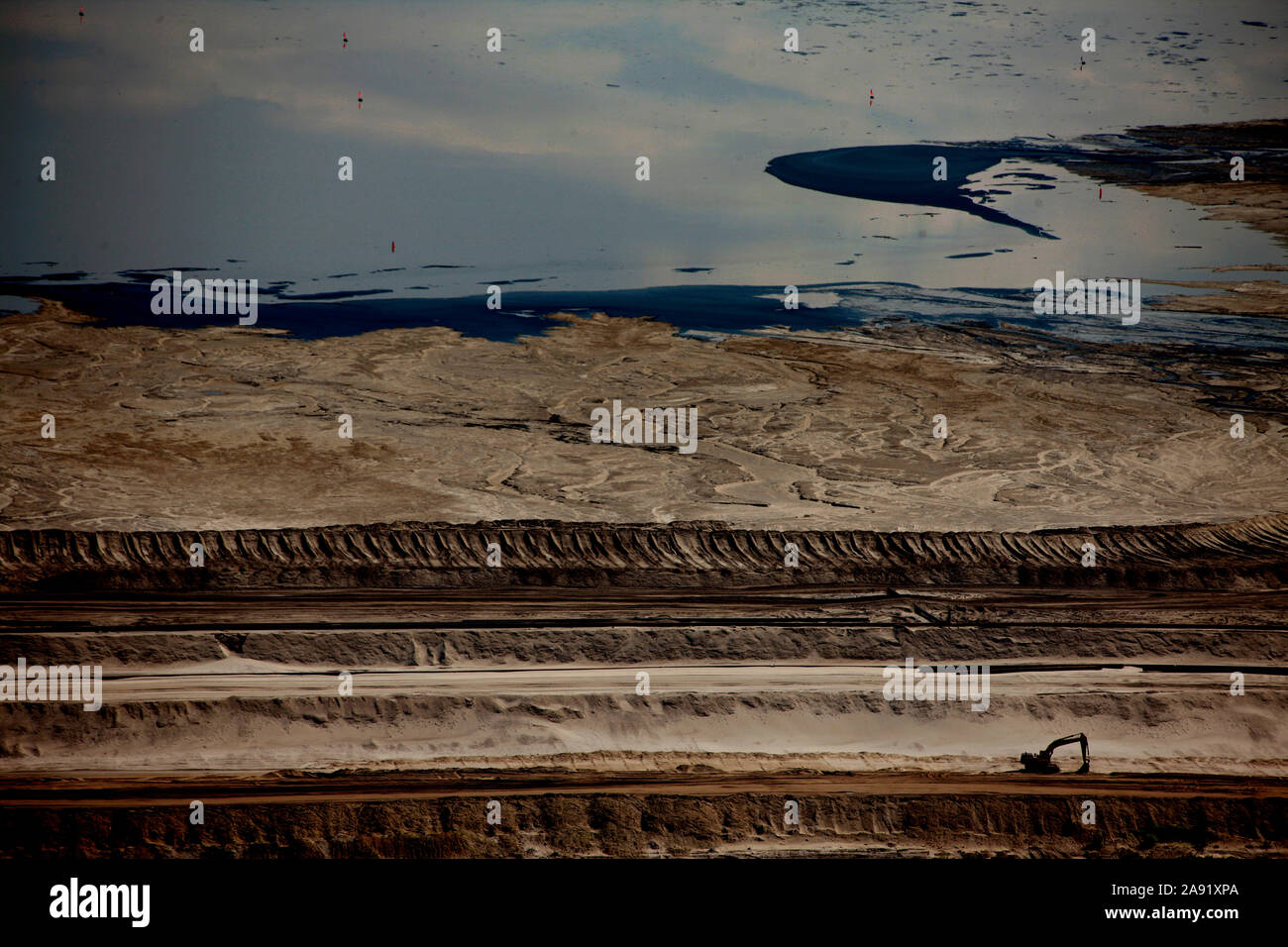 Planierraupen und Schürfraupen verbreiten sich die toxischen Abfälle in einer der enormen Bergeteiche in Fort McMurray in Alberta, Kanada. Die Teiche sind unter der größte Mann, Strukturen in der Welt, die mehr als 175 Quadratkilometern. Sie stellen eine zusätzliche Herausforderung an die Oil Sands Produktion: auch nach Ende der Produktion, kann es bis zu 30 Jahre für den Schlick, die in den Teichen bis zu trocknen. Das kontaminierte Wasser ist giftig für alle Lebewesen. Die Athabasca Oil Sands Kaution gehört zu den größten in der Welt. Die Bitumen, auch allgemein namens tar (tar sands), enthält viele hydrocarbo Stockfoto