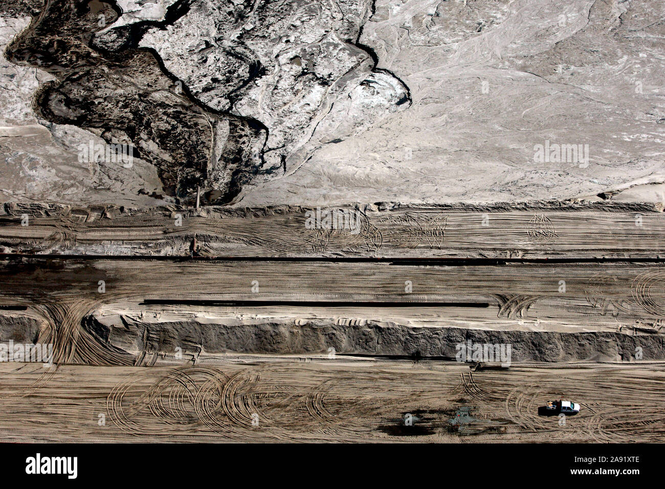Bulldozer verbreiten sich die toxischen Abfälle in einer der enormen Bergeteiche in Fort McMurray in Alberta, Kanada. Die Teiche sind unter der größte Mann, Strukturen in der Welt, die mehr als 175 Quadratkilometern. Sie stellen eine zusätzliche Herausforderung an die Oil Sands Produktion: auch nach Ende der Produktion, kann es bis zu 30 Jahre für den Schlick, die in den Teichen bis zu trocknen. Das kontaminierte Wasser ist giftig für alle Lebewesen. Die Athabasca Oil Sands Kaution gehört zu den größten in der Welt. Die Bitumen, auch allgemein namens tar (tar sands), enthält viele Kohlenwasserstoffe, aber notori ist Stockfoto