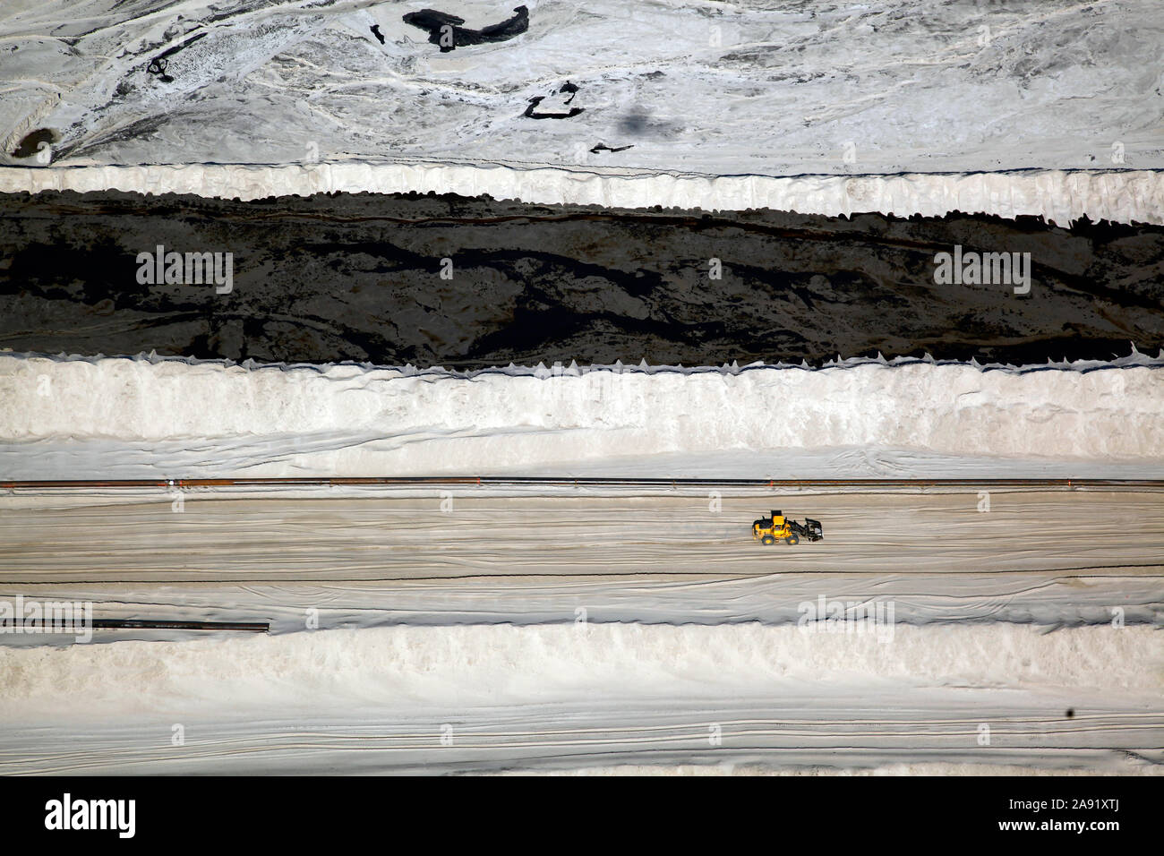 Bulldozer verbreiten sich die toxischen Abfälle in einer der enormen Bergeteiche in Fort McMurray in Alberta, Kanada. Die Teiche sind unter der größte Mann, Strukturen in der Welt, die mehr als 175 Quadratkilometern. Sie stellen eine zusätzliche Herausforderung an die Oil Sands Produktion: auch nach Ende der Produktion, kann es bis zu 30 Jahre für den Schlick, die in den Teichen bis zu trocknen. Das kontaminierte Wasser ist giftig für alle Lebewesen. Die Athabasca Oil Sands Kaution gehört zu den größten in der Welt. Die Bitumen, auch allgemein namens tar (tar sands), enthält viele Kohlenwasserstoffe, aber notori ist Stockfoto