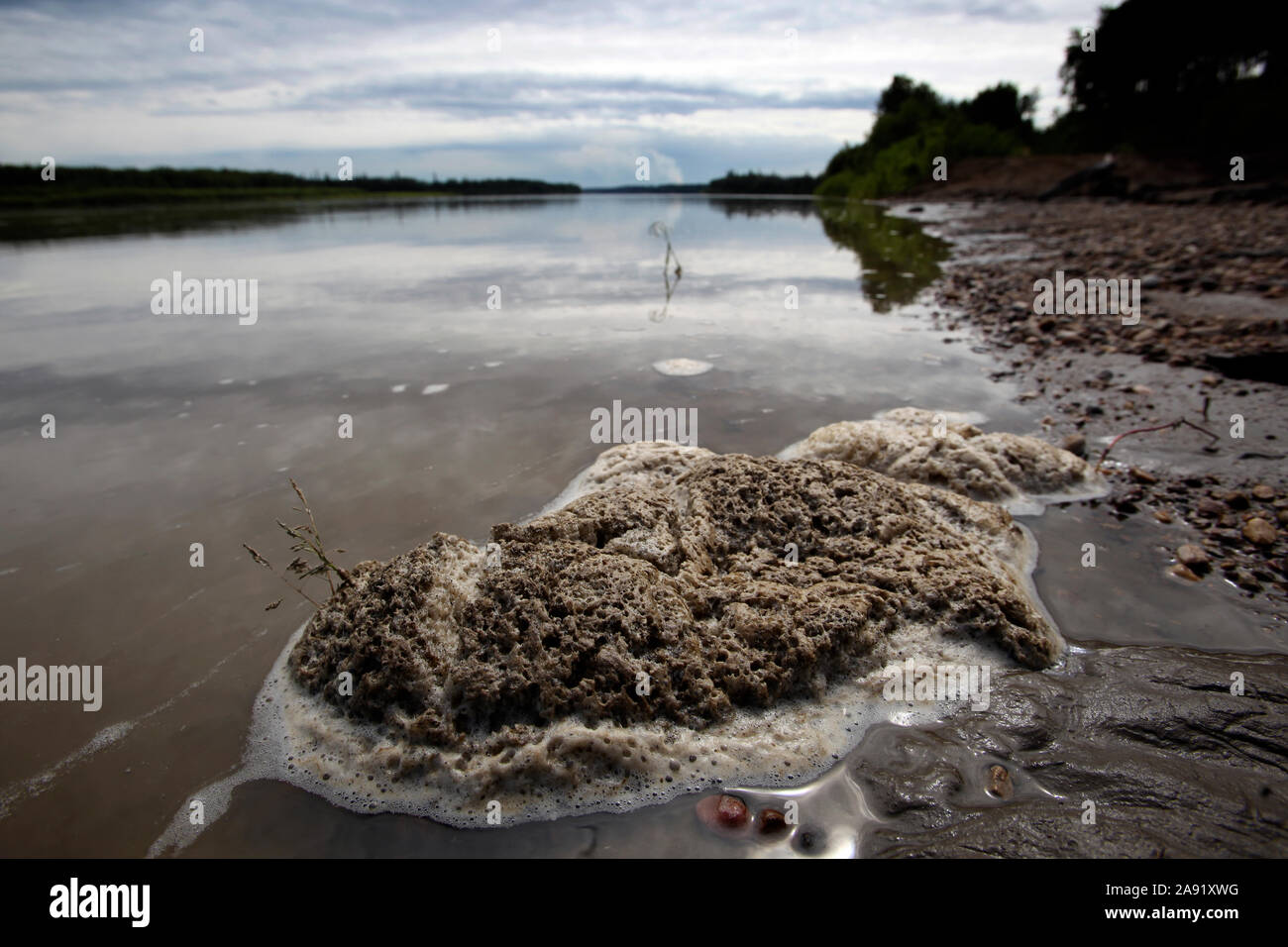Schaum auf der Oberfläche eines Flusses in der Nähe der Bergeteiche von den Ölgesellschaften werden toxische Abfälle zu deponieren. Die chipewyan Band der ersten Nation, lebt in Fort McKay sind über die Umweltauswirkungen, die das sand Unternehmen in ihrer Nachbarschaft zu betreiben besorgt. Stockfoto