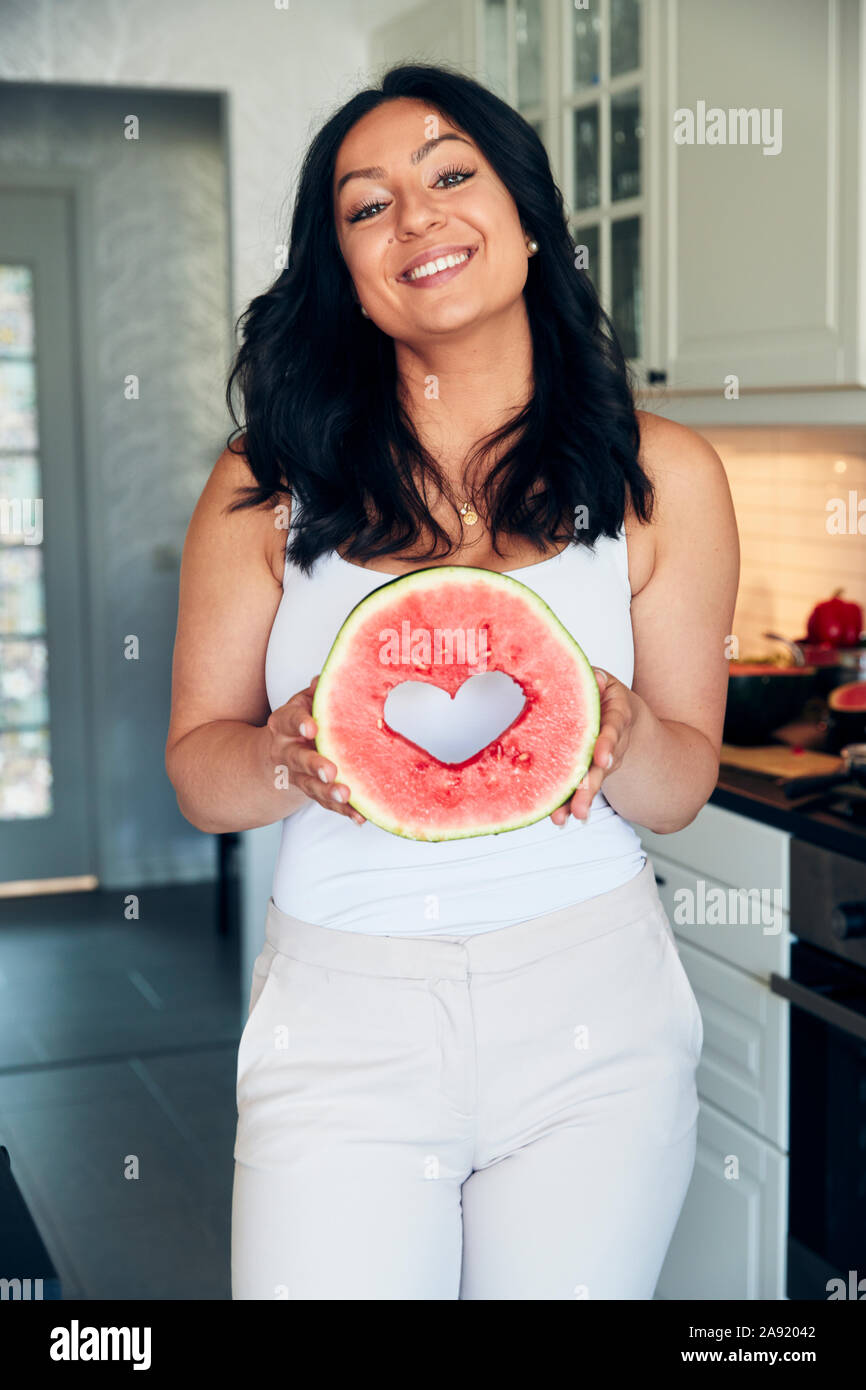 Die Frau in der Küche holding Wassermelone Stockfoto