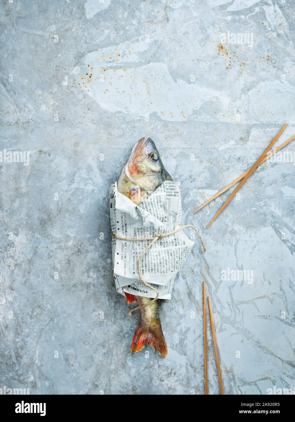 Roher Fisch eingewickelt in Zeitung Stockfoto