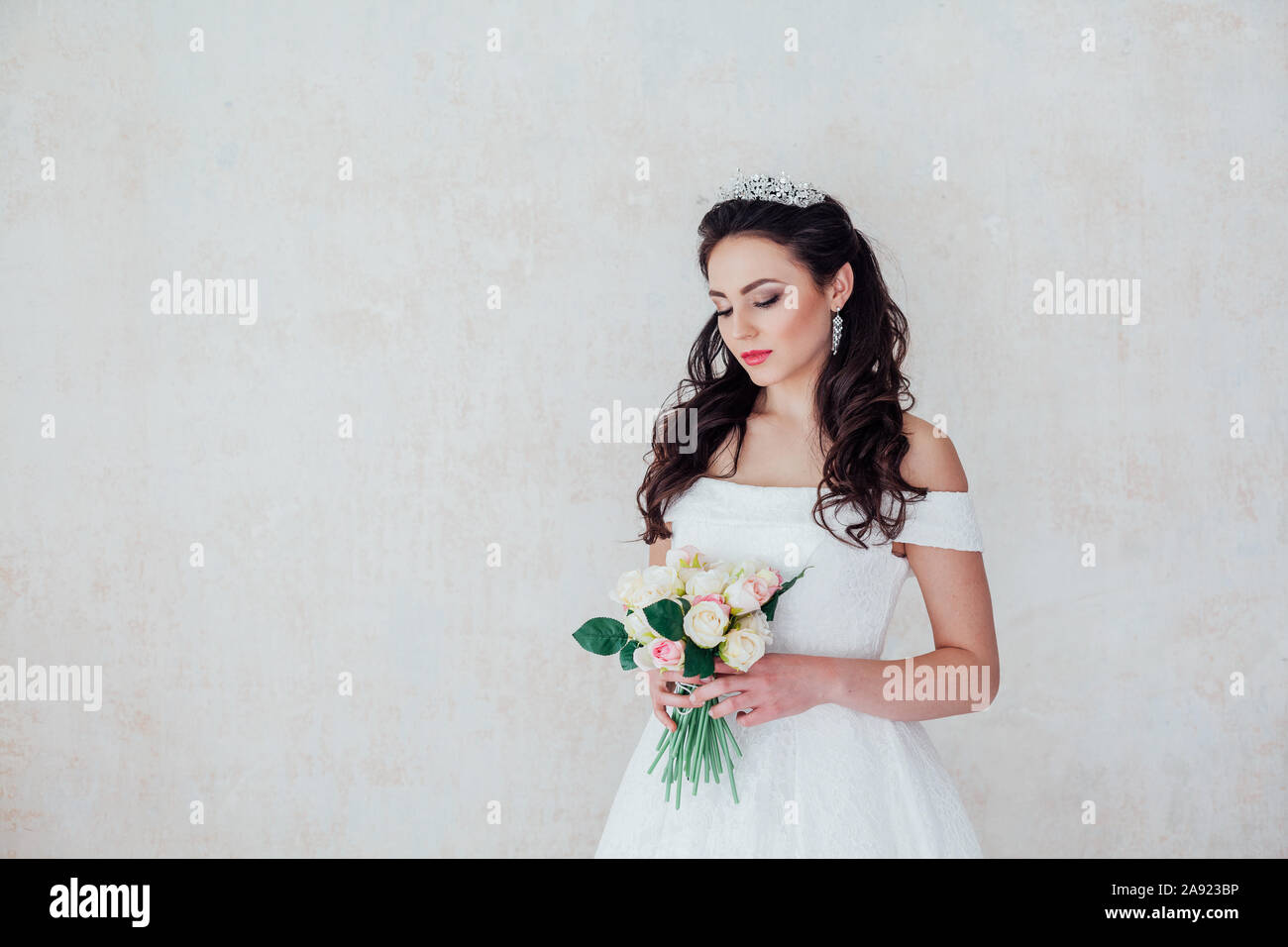 Braut Prinzessin steht in einem Brautkleid mit Blumen Stockfoto