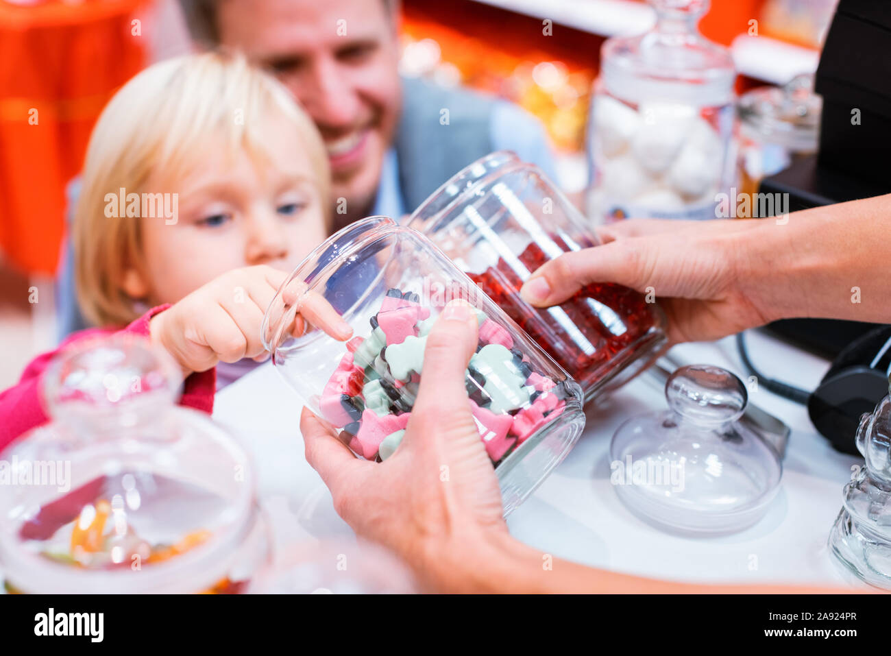 Kind greifen einige Süßigkeiten aus einer jar im Süßigkeitenladen Stockfoto
