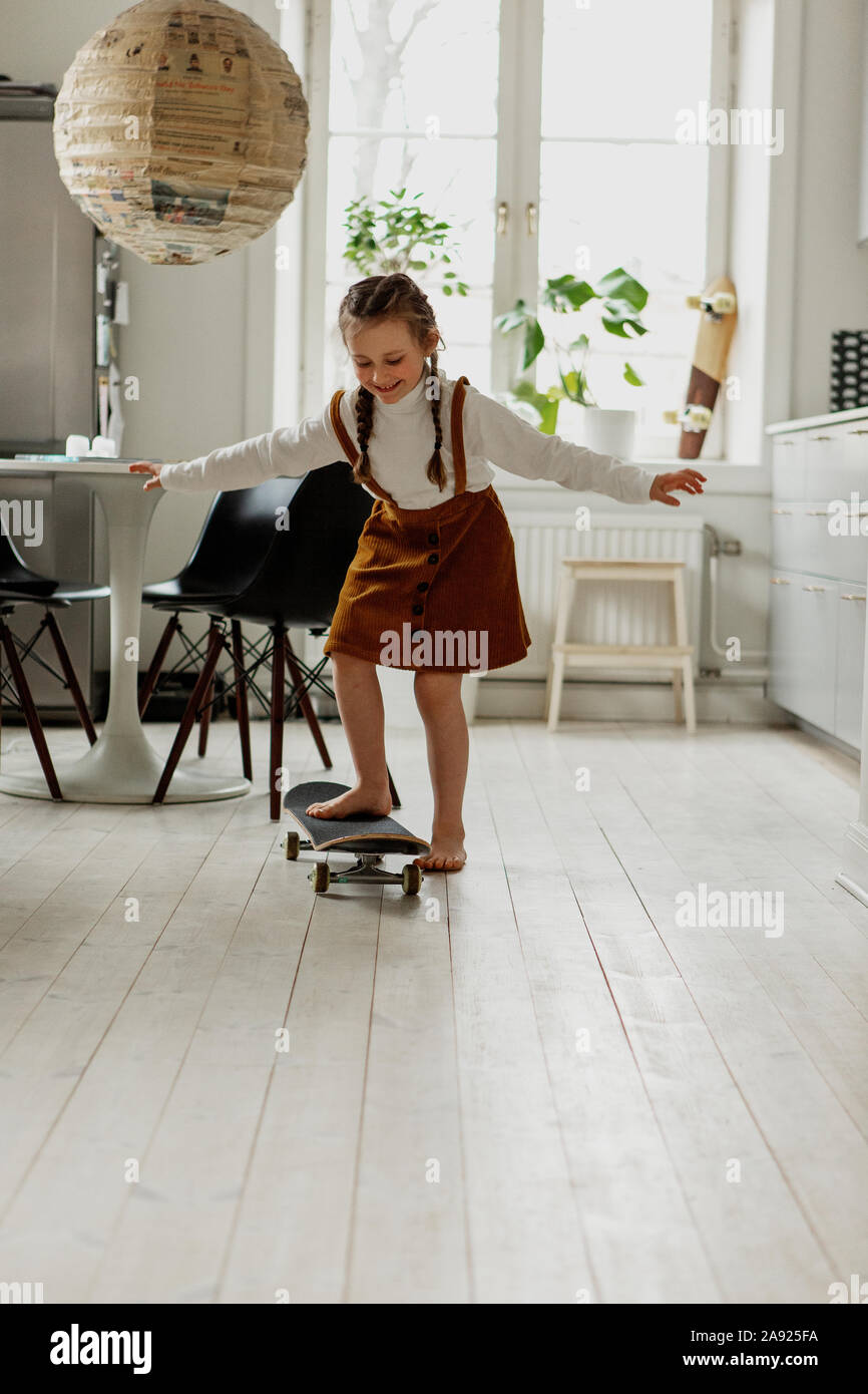Mädchen auf Skateboard zu Hause Stockfoto