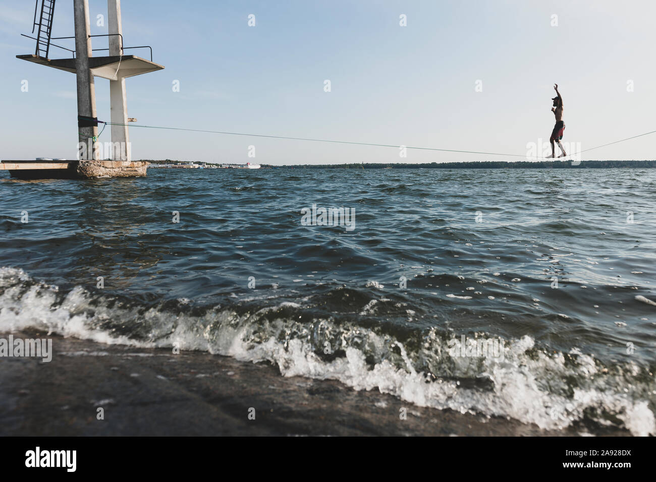 Person auf slickline über dem Meer Stockfoto